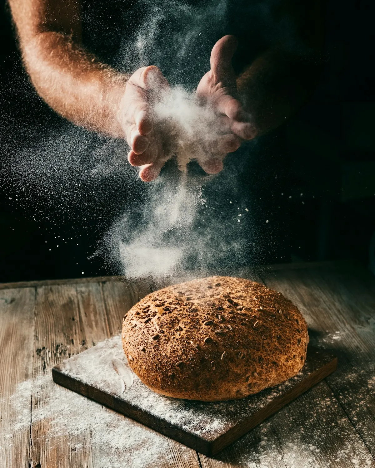 Un boulanger fleurit une miche de pain.